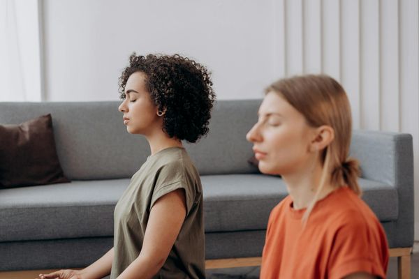 Person practicing a focused yoga pose in a minimalist, serene room.